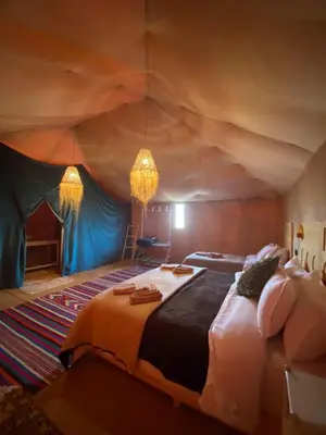 a bedroom with a large bed in a tent at Morocco Desert Luxury Camp in Merzouga