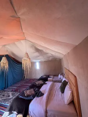 a bedroom with a bed in a tent at Morocco Desert Luxury Camp in Merzouga