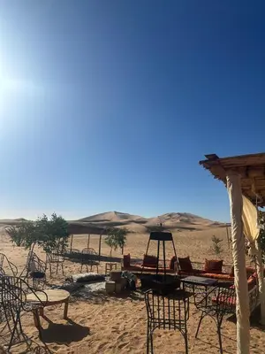 a group of tables and chairs in the desert at Morocco Desert Luxury Camp in Merzouga