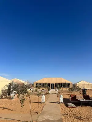 a large building in the middle of a desert at Morocco Desert Luxury Camp in Merzouga