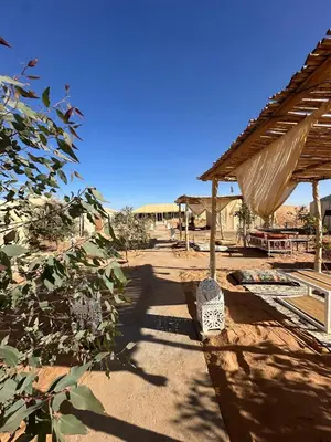 a walkway with a roof and a table and a building at Morocco Desert Luxury Camp in Merzouga