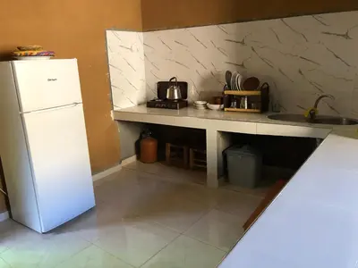 a kitchen with a white refrigerator and a sink at Guest House Tigminou in Setti Fatma