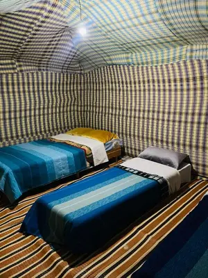 a room with two beds in a checkered room at Sahara camel tours camp in Merzouga