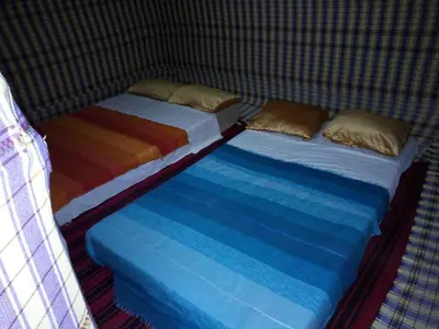 two beds sitting next to each other in a room at Sahara camel tours camp in Merzouga