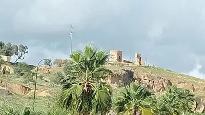 a castle on top of a hill with palm trees at Dawya terrace in Fès
