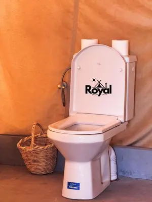 a toilet with a sign on the back of it at Royal Sands Camp in Merzouga