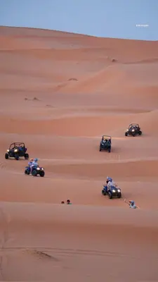 a group of people on atvs in the desert at Royal Sands Camp in Merzouga