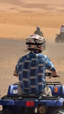 a man riding a four wheeler in the desert at Royal Sands Camp in Merzouga