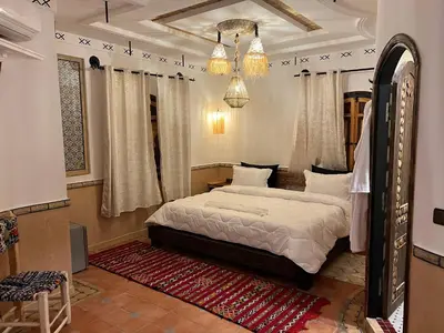 a bedroom with a bed and a chandelier at Grand Canyon Lodge Dades in Aït Idaïr