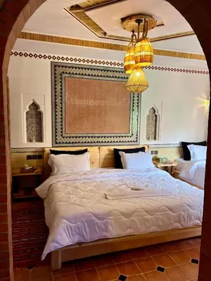 a bedroom with a large bed with a chandelier at Grand Canyon Lodge Dades in Aït Idaïr