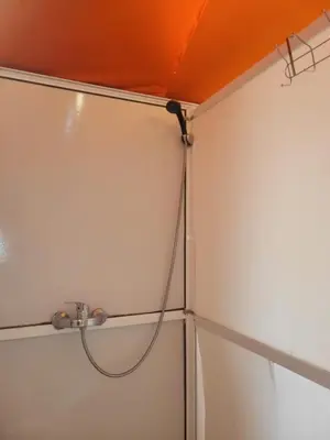 a shower with a hose hanging from a ceiling at Bright Star Desert Camp in Merzouga