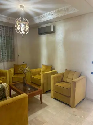a living room with yellow furniture and a chandelier at Villa SKYVIEW in Beni Mellal