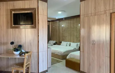 a hotel room with two beds and a television at Hotel Oasis Palace in Er Rachidia