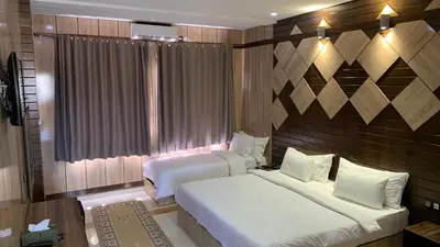 a hotel room with two beds and a window at Hotel Oasis Palace in Er Rachidia