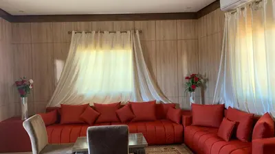 a living room with a red couch and a window at Hotel Oasis Palace in Er Rachidia