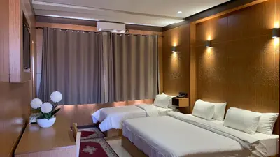 a hotel room with two beds and a table at Hotel Oasis Palace in Er Rachidia