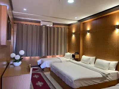 a hotel room with two beds and a television at Hotel Oasis Palace in Er Rachidia