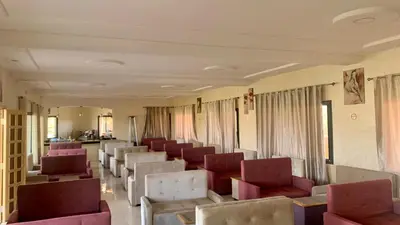an empty waiting room with chairs and curtains at Hotel Oasis Palace in Er Rachidia