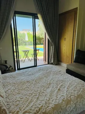 a bedroom with a bed and a view of a patio at Entire villa with private pool in Marrakech in Marrakech