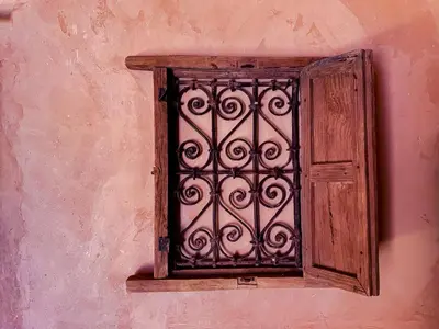 an open window on the side of a pink wall at Maison d'hôtes imouzzar asfalou in Aït Ben Haddou