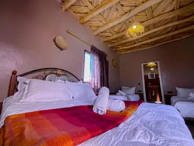 a bedroom with a large bed with two pillows on it at Maison d'hôtes imouzzar asfalou in Aït Ben Haddou