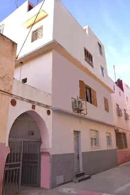 a white building with an archway in front of it at chez zoubida in Meknès