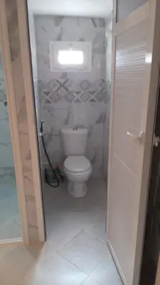 a bathroom with a toilet and a window at chez zoubida in Meknès