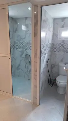 a bathroom with a glass shower with a toilet at chez zoubida in Meknès