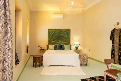 a bedroom with a bed and a painting on the wall at Villa les Oliviers avec piscine privée & jardin - Atlas view in Marrakech