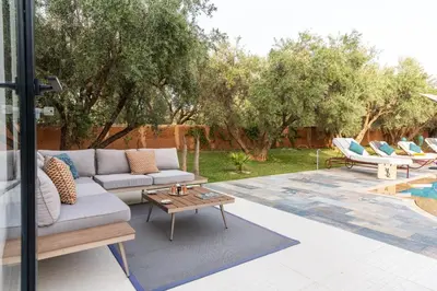 a patio with a couch and a table at Villa les Oliviers avec piscine privée & jardin - Atlas view in Marrakech
