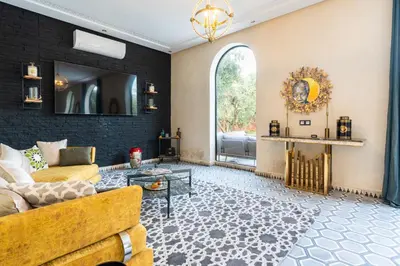 a living room with a couch and a mirror at Villa les Oliviers avec piscine privée & jardin - Atlas view in Marrakech