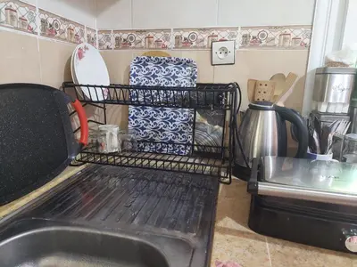 a kitchen with a sink and a dish drying rack at Hi Home in Meknès