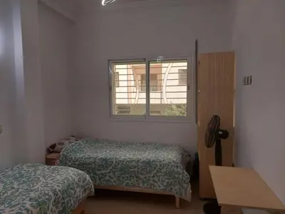 a small room with two beds and a window at Hi Home in Meknès