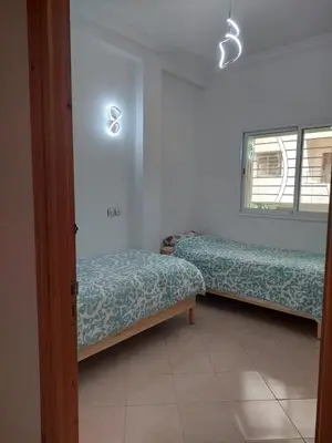 a room with two beds and a window at Hi Home in Meknès