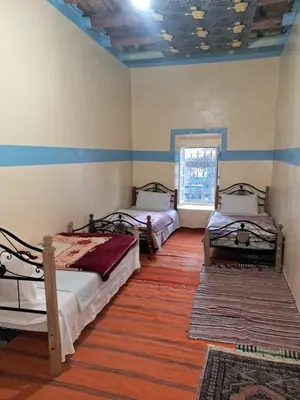 a room with two beds and a window at Maison d'hôte Riad Todra in Tinerhir