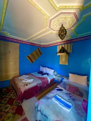 two beds in a room with blue walls and a ceiling at Maison d'hôte Riad Todra in Tinerhir