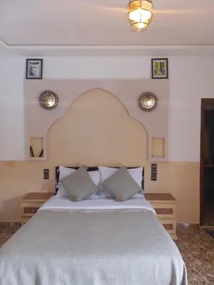 a bedroom with a large bed with two pillows at Merzouga Riad Desert Man in Merzouga