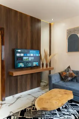 a living room with a blue couch and a flat screen tv at La Terrassa appartement climatisé in Azrou
