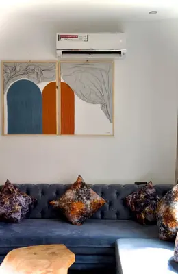 a blue couch against a wall with pillows on it at La Terrassa appartement climatisé in Azrou