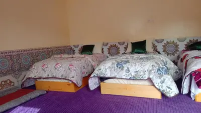 two beds in a room with purple carpet at AYA Farm,Ferme d'hotes Aguelmous in Khenifra