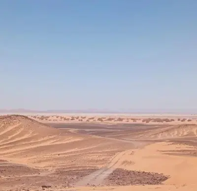 a view of the desert with a road in the distance at Guest House Nomad Life in Merzouga