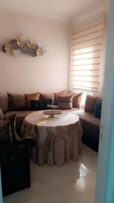 a living room with a table and a couch at Appartement Basatine in Fès