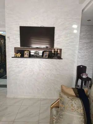 a living room with a television on a wall at Appartement Basatine in Fès