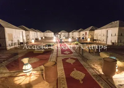 a row of houses at night with lights at Merzouga Desert Camps in Merzouga