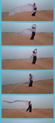a woman is performing a dance in the desert at Riad camels house in Merzouga