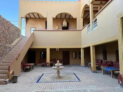 a courtyard with a fountain in the middle of a building at Riad camels house in Merzouga