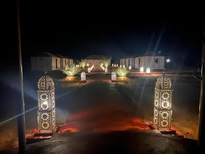 a parking lot at night with lights on it at Idir Luxury Camp in Merzouga