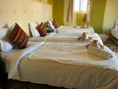 a room with three beds with stuffed animals on them at Idir Luxury Camp in Merzouga
