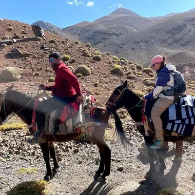 two people riding on horses on a mountain at GITE ROURAL TATIOUINE Midelt in Tattiouine