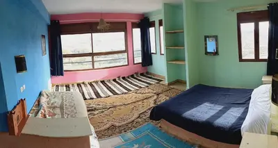 a bedroom with a bed and a couch and a window at Auberge Assays in Taliouine